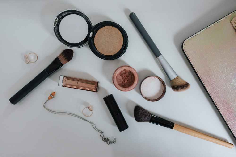flat lay photography of makeup brushes and compacts