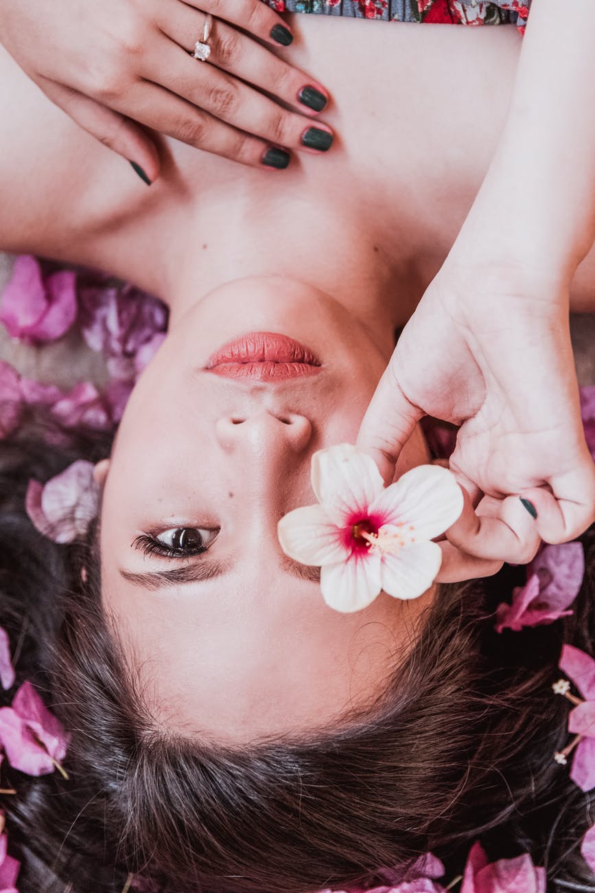 photo of woman holding pink flower