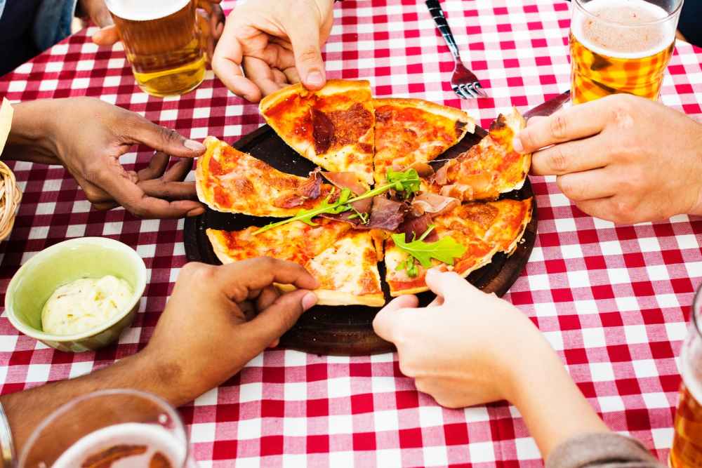 people holding sliced pizza